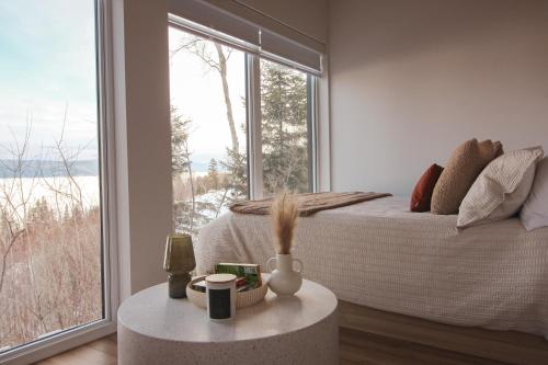 a bedroom with a bed and a large window at Refuge du Fjord in Saguenay
