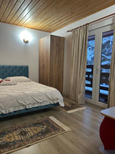 a bedroom with a bed and a sliding glass door at Insieme in Vidra