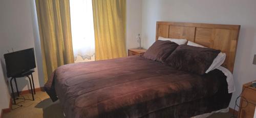 a bedroom with a large bed and a television at Playa Las Torpederas in Valparaíso