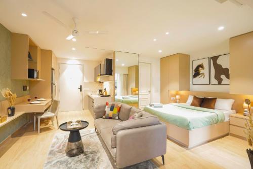 a living room with a bed and a couch in a room at Aerovista Suites - Neon Homeotel- 1 kms from Airport in Pune