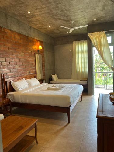 a bedroom with two beds and a brick wall at Savana Stay - A Boutique Hotel in Pondicherry