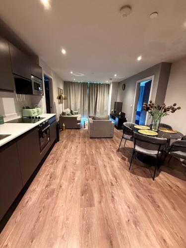 a large kitchen and living room with a table and chairs at 2 bedroom APT in City Centre in Manchester
