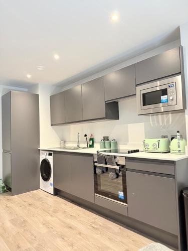a kitchen with a sink and a microwave at 2 bedroom APT in City Centre in Manchester
