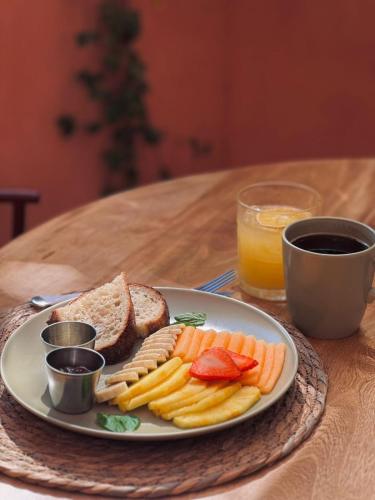 a plate of food on a table with a sandwich and fruit at Casa Toro La Punta in Puerto Escondido