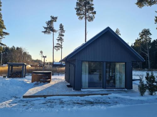 a small shed in the snow with trees in the background at Salmistu Saunamaja in Salmistu