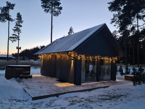 a house with lights on it in the snow at Salmistu Saunamaja in Salmistu