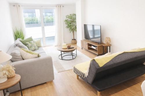 a living room with a couch and a tv at Zone 1 Bright and Modern 3 Bed Apt Hyde Park Central London in London