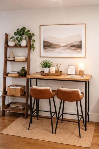 a desk with two chairs in a room with a shelf at Zone 1 Bright and Modern 3 Bed Apt Hyde Park Central London in London