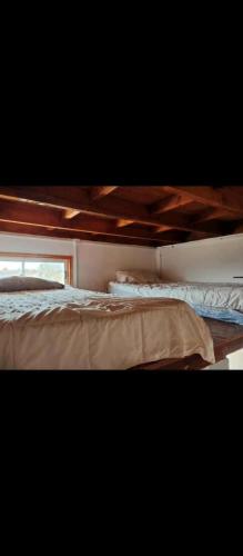 a bed in a room next to a window at Loft centro de el tabo in El Tabo