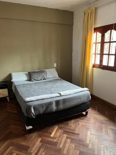 a bed in a bedroom with a wooden floor at Casa balcarce in Salta