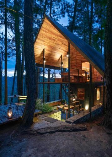 a house in the woods with a blue roof at Kaya Retreat in Diyatalawa