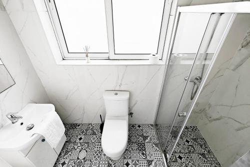 a bathroom with a toilet and a sink and a window at Cosy room 4 in Pieta