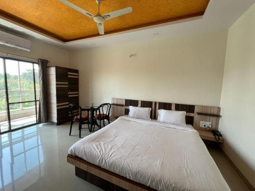 a bedroom with a bed and a table with chairs at Gugal Bliss in Mahabaleshwar