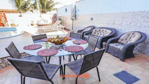 a table and chairs with a bowl of fruit on it at Suite em Guriri Norte com Piscina e Academia in São Mateus