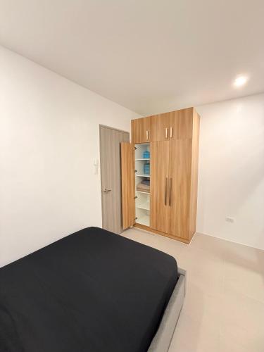 a white room with a bed and a cabinet at Kaizen Urban Retreat - Elevate Your Stay in Calo