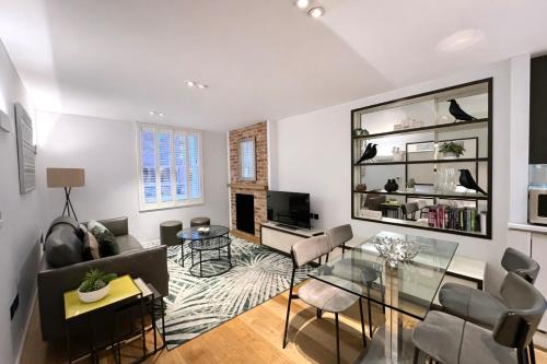 a living room with a glass table and chairs at Wigmore Suites Serviced Apartments by Globe Apartments in London