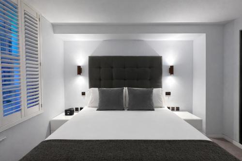 a bedroom with a large white bed with a black headboard at Wigmore Suites Serviced Apartments by Globe Apartments in London