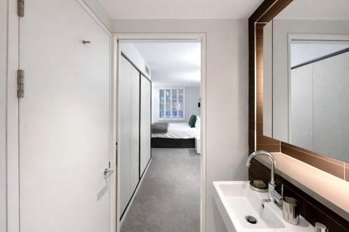 a bathroom with a sink and a mirror at Wigmore Suites Serviced Apartments by Globe Apartments in London