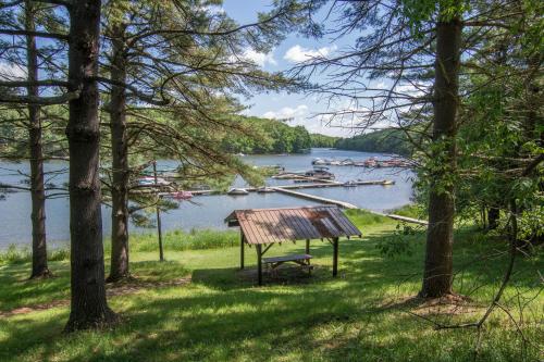 a bench in the grass next to a lake with boats at Woodlore by Railey Vacations in Swanton