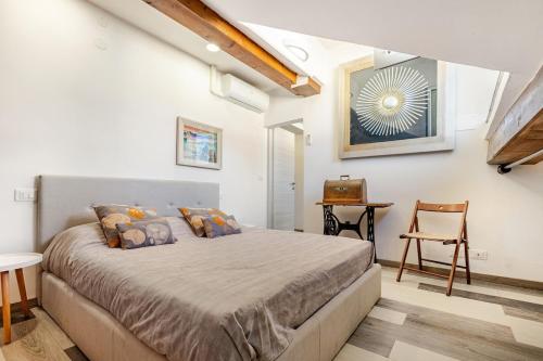 a bedroom with a bed and a table and a chair at Mansarda in pieno centro in Savona