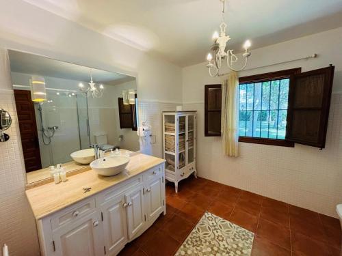 a bathroom with two sinks and a large mirror at Dehesa La Parrilla - VUT- Eventos in Pepino