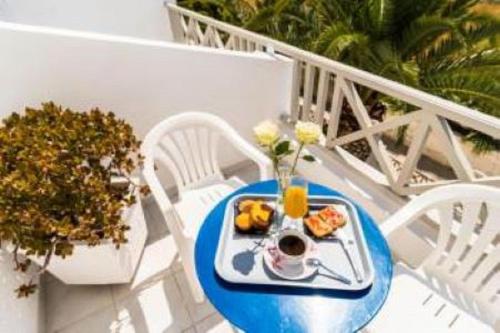 ein Teller mit Essen auf einem Tisch auf einem Balkon in der Unterkunft Villa Kalamia Dolphin in Perissa