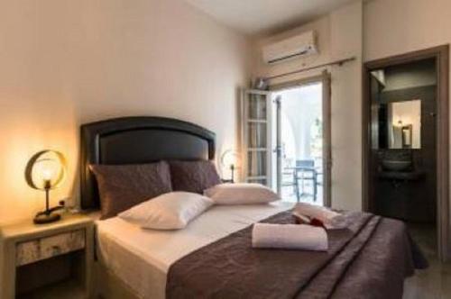 ein Schlafzimmer mit einem großen Bett und einem Spiegel in der Unterkunft Villa Kalamia Dolphin in Perissa