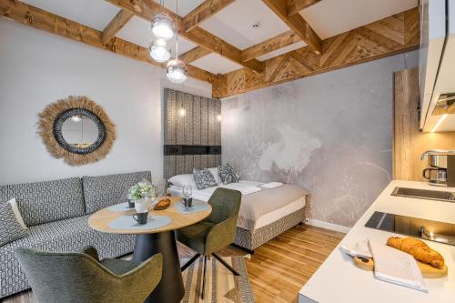 a room with a bed and a table and chairs at Aparthotel Góralski Spa & Restaurant in Białka Tatrzańska