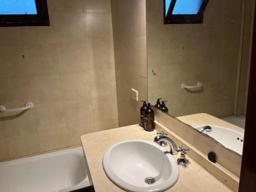 a bathroom with a sink and a bath tub at Casa balcarce in Salta