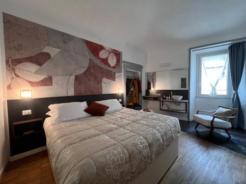 a bedroom with a large bed with a painting on the wall at DIMOR'A' ROOMS in Tuscany in Pitigliano