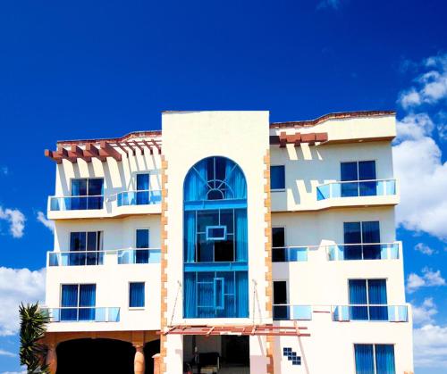 a white building with blue windows and a blue sky at Hotel Cancalli Tlaxcala in Tlaxcala de Xicohténcatl