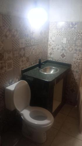 a bathroom with a toilet and a sink at Elu in Ingeniero Giagnoni