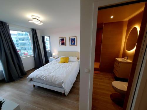 a bedroom with a white bed and a bathroom at Paris vous aime in Le Kremlin-Bicêtre