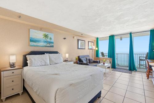 a bedroom with a large bed and a balcony at Daytona Harbour Beach Resort Unit 808 in Daytona Beach