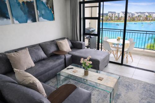 a living room with a couch and a table at Spectacular Lagoon Facing Apartment - The Blyde in Pretoria