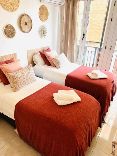 two beds in a hotel room with towels on them at Palmeras Puerto Torrevieja in Torrevieja