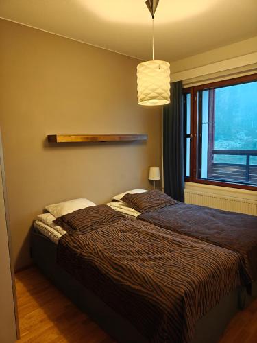 a bedroom with a bed and a large window at Chalet Ylläs C413 included bed linen and towels in Ylläs