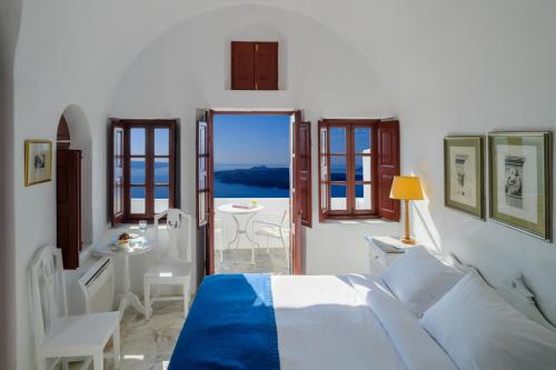 a bedroom with a bed and a view of the ocean at Aigialos Luxury Traditional Settlement in Fira
