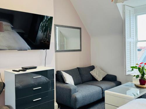 a living room with a couch and a bedroom at Penthouse Suite, Sea View, Close to Shops, Beach and Train in St. Leonards
