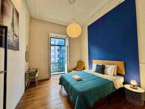 a blue bedroom with a bed and a blue wall at Ambiente Hostel in Lisbon