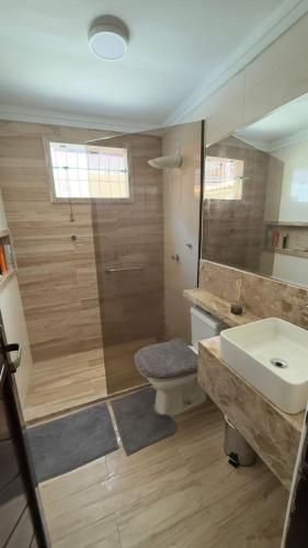 a bathroom with a sink and a toilet and a shower at Casa maricota in Porto Seguro