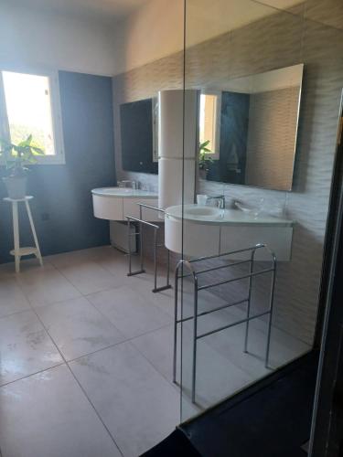 a bathroom with two sinks and two bar stools at Maison Sol Air in Montazels
