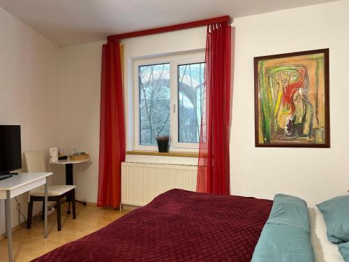 a bedroom with a bed and a window with red curtains at Hotel Zemlinski in Payerbach