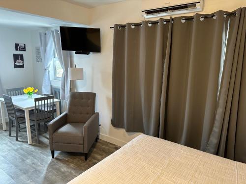 a bedroom with curtains and a chair and a table at Hotel Ponce de Leon in Miami