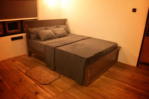 a small bed in a room with a wooden floor at Patrius Bungalow by Daddy's Nest in Diyatalawa