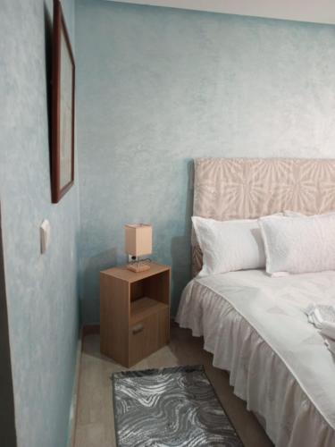 a bedroom with a bed and a night stand with a lamp at Appartement pieds dans l'eau Aghroud in Tamri