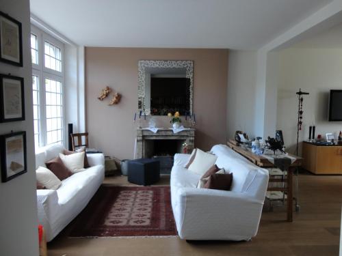 a living room with two white couches and a fireplace at B&B Maison Angélus in Saint Malo