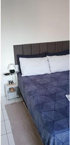 una camera da letto con un letto con un piumone blu di Ap simples aconchego a Santarém