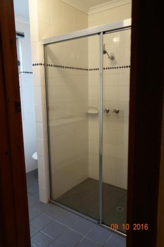 a shower with a glass door in a bathroom at Morella Farmstay in Cape Jervis