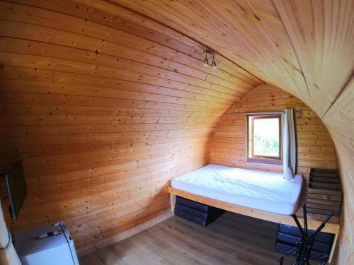 a bedroom in a log cabin with a bed in it at Clover in Welland